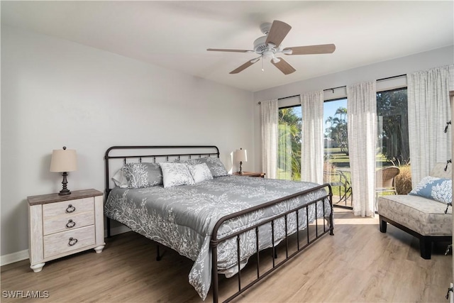 bedroom with wood-type flooring, ceiling fan, and access to outside