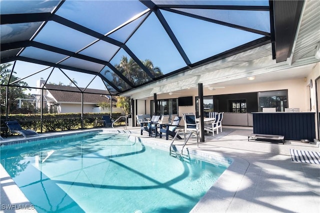 view of swimming pool featuring a patio and a lanai