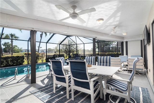 view of patio with ceiling fan and glass enclosure