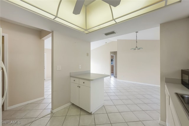 kitchen featuring ceiling fan, kitchen peninsula, light tile patterned floors, hanging light fixtures, and white cabinets