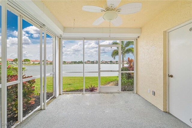 unfurnished sunroom with a water view and ceiling fan