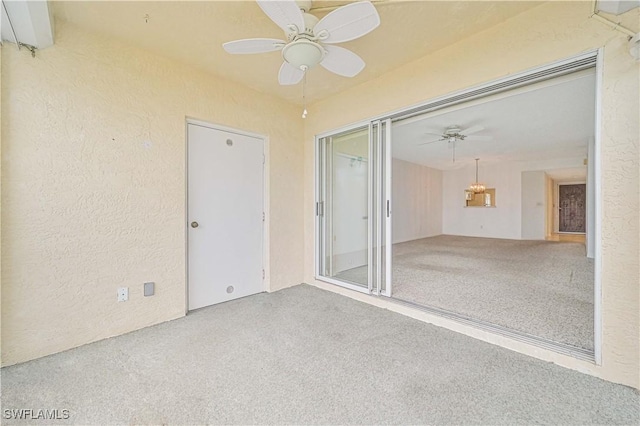 spare room featuring a textured wall, carpet flooring, and a ceiling fan