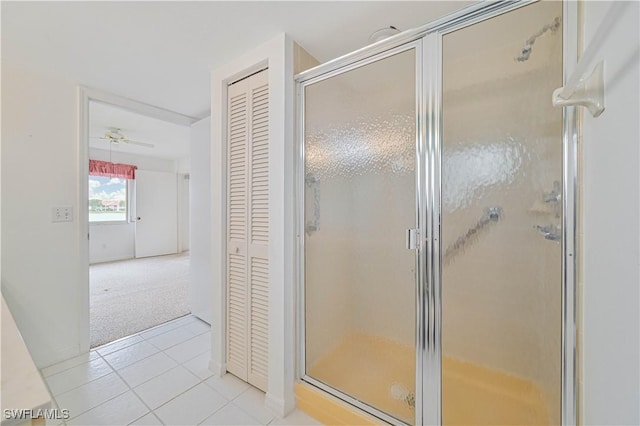 full bathroom featuring tile patterned flooring, a shower stall, and a closet