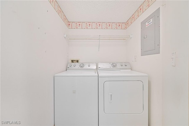 laundry room with washer and dryer, laundry area, electric panel, and a textured ceiling