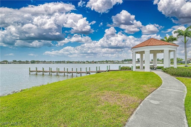 dock area with a water view, a lawn, and a gazebo