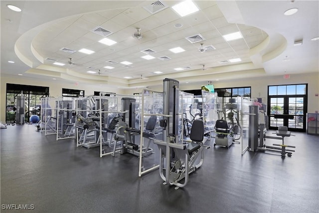 gym featuring a raised ceiling and a drop ceiling