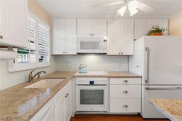 kitchen featuring white cabinetry, sink, decorative backsplash, and white appliances