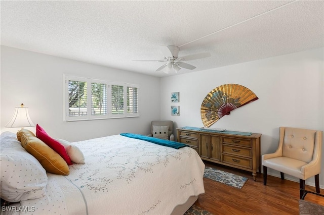 bedroom with ceiling fan, dark hardwood / wood-style flooring, and a textured ceiling