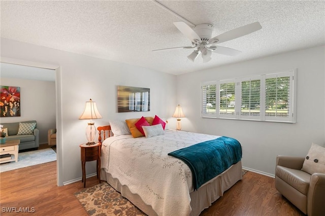 bedroom featuring ceiling fan, a textured ceiling, and hardwood / wood-style flooring