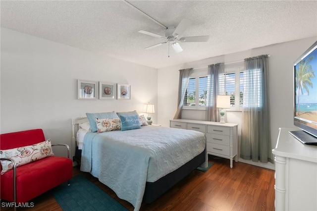 bedroom featuring ceiling fan, dark hardwood / wood-style floors, and a textured ceiling