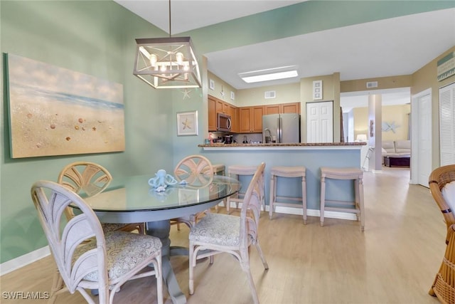 dining space featuring a chandelier and light hardwood / wood-style flooring