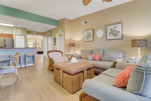 living room featuring ceiling fan and light hardwood / wood-style flooring