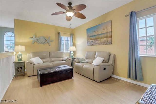 living room with light wood-type flooring and ceiling fan