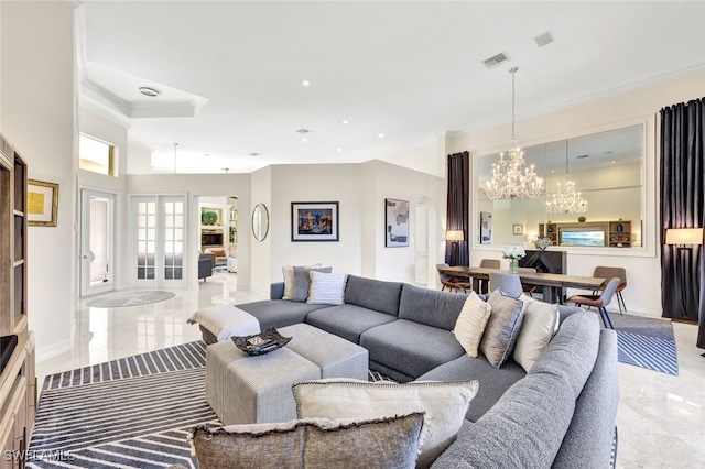 living room featuring ornamental molding, an inviting chandelier, and french doors