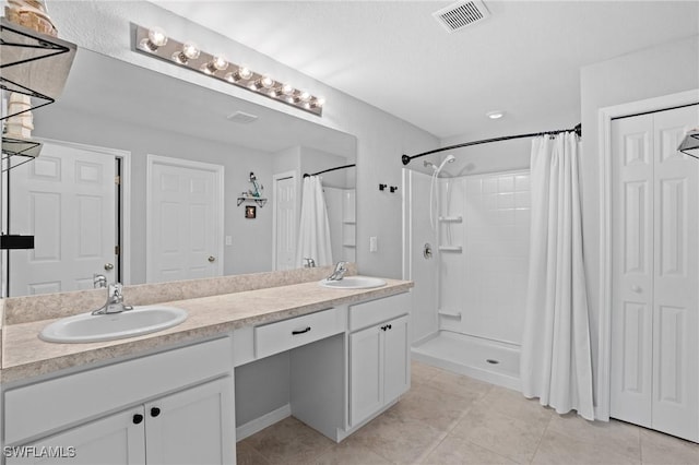 bathroom with a closet, visible vents, and a sink