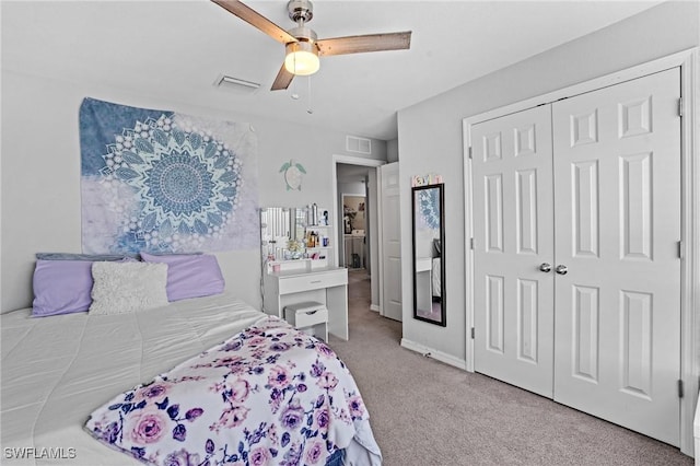 bedroom featuring a ceiling fan, a closet, visible vents, and light colored carpet