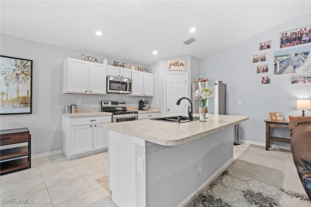 kitchen with stainless steel appliances, light countertops, a kitchen island with sink, white cabinets, and a sink