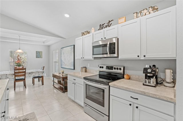 kitchen featuring stainless steel appliances, white cabinets, light countertops, and decorative light fixtures