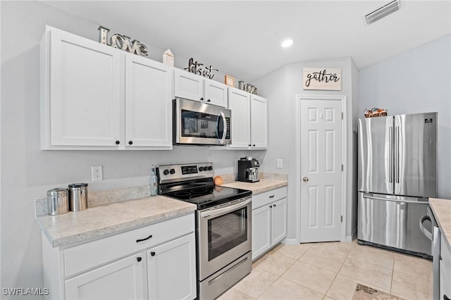 kitchen with visible vents, white cabinetry, stainless steel appliances, and light countertops