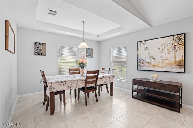 dining room with light tile patterned flooring, a raised ceiling, visible vents, and baseboards