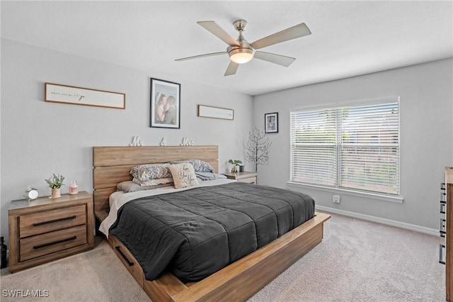 bedroom featuring light carpet, ceiling fan, and baseboards