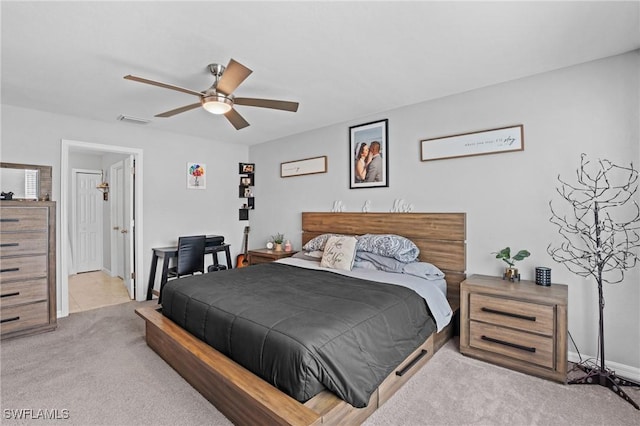 bedroom with light carpet, ceiling fan, visible vents, and baseboards