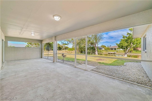 unfurnished sunroom featuring a water view