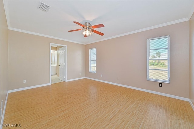 empty room featuring crown molding and light wood-type flooring