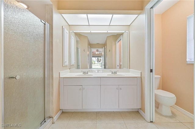 bathroom with tile patterned flooring, vanity, a shower with shower door, and toilet