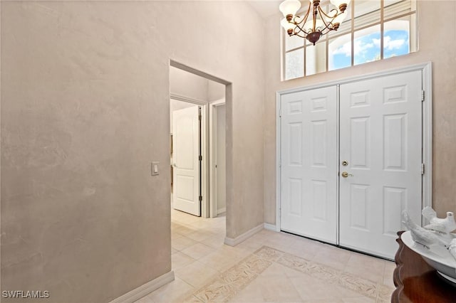 tiled entrance foyer with a chandelier