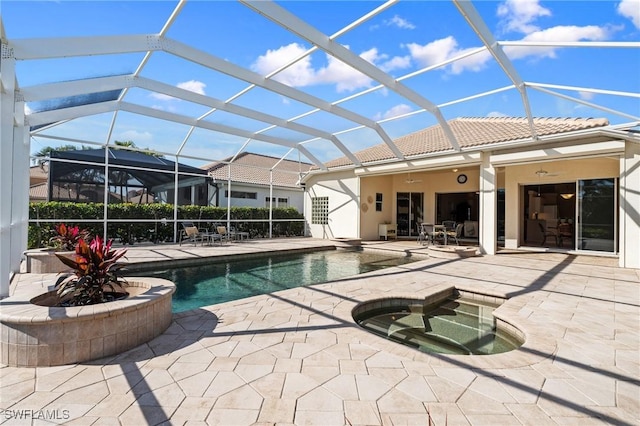 view of swimming pool with ceiling fan, a patio, a hot tub, and glass enclosure