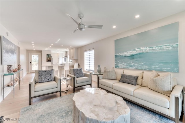 living room featuring ceiling fan and light hardwood / wood-style floors