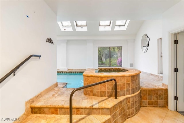 bathroom with lofted ceiling with skylight and tile patterned floors