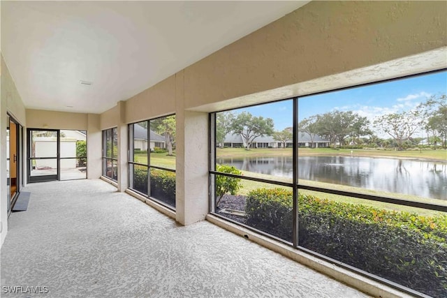 unfurnished sunroom featuring a water view