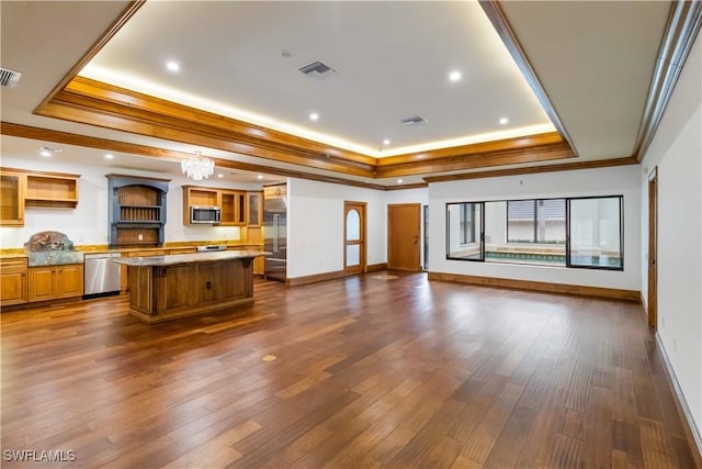 unfurnished living room featuring a raised ceiling, ornamental molding, dark hardwood / wood-style floors, and an inviting chandelier