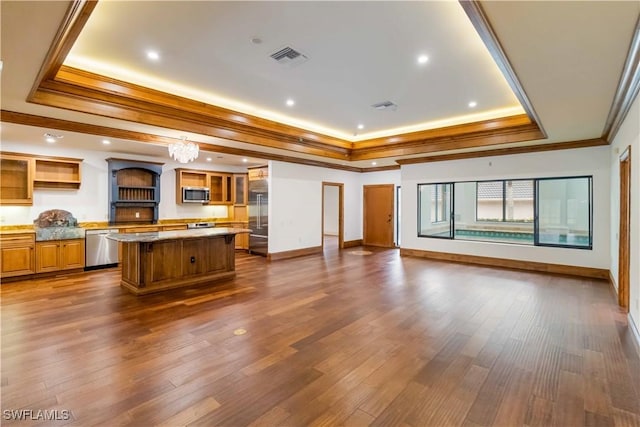 unfurnished living room featuring an inviting chandelier, dark hardwood / wood-style floors, ornamental molding, and a raised ceiling