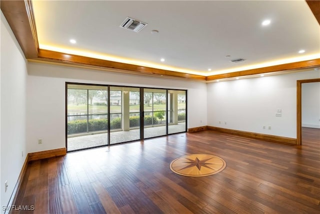 unfurnished room featuring hardwood / wood-style flooring and a tray ceiling