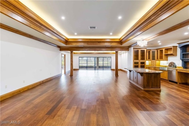 kitchen featuring a raised ceiling, dishwasher, a kitchen island, and crown molding