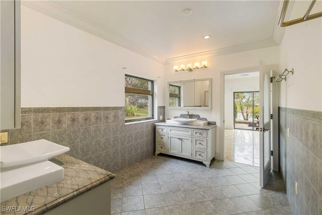 bathroom featuring tile walls, vanity, crown molding, and tile patterned floors