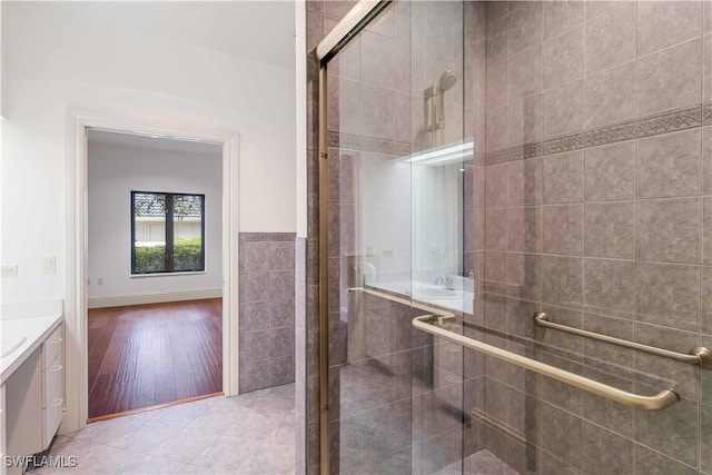 bathroom featuring vanity, tile walls, an enclosed shower, and tile patterned floors