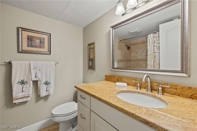 bathroom featuring toilet, vanity, and walk in shower