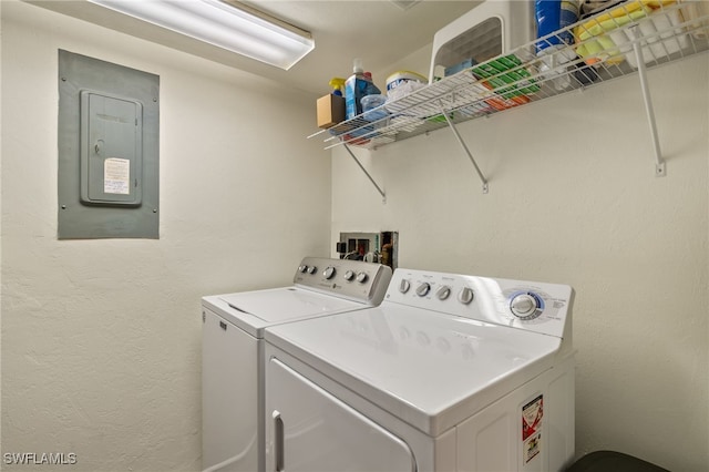 clothes washing area with washing machine and dryer and electric panel