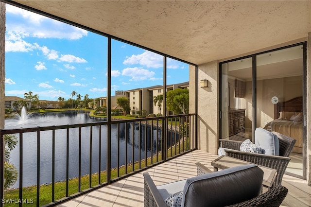 sunroom featuring a water view