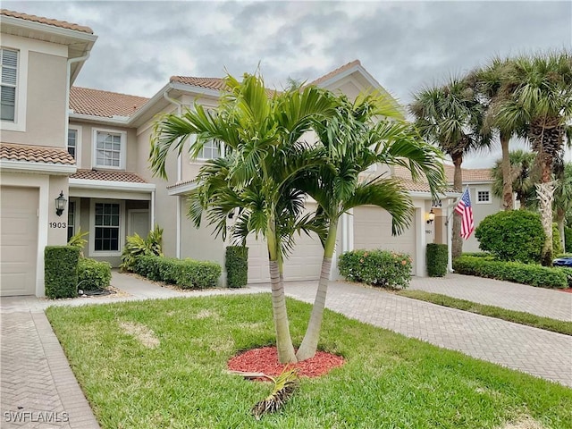 mediterranean / spanish house with a garage and a front yard