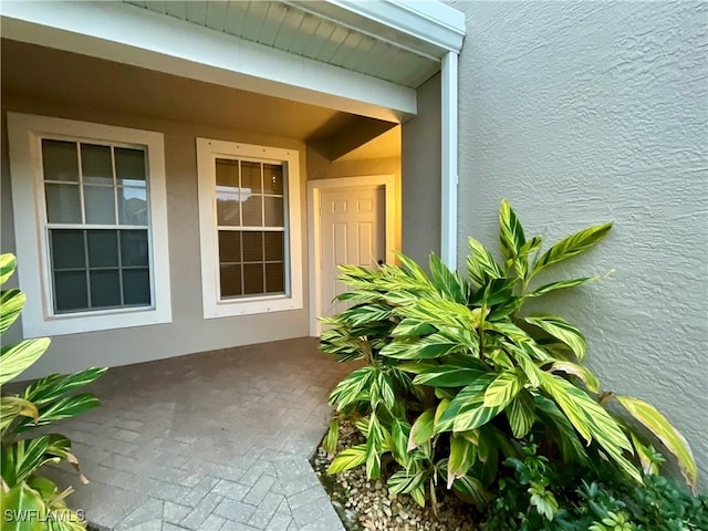 view of exterior entry with a patio