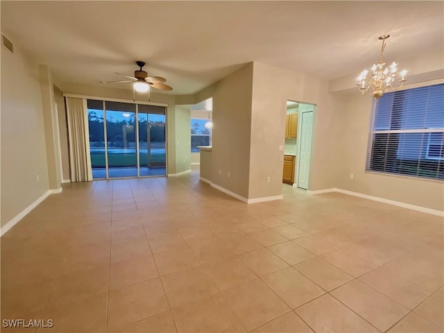 empty room featuring ceiling fan with notable chandelier and light tile patterned floors