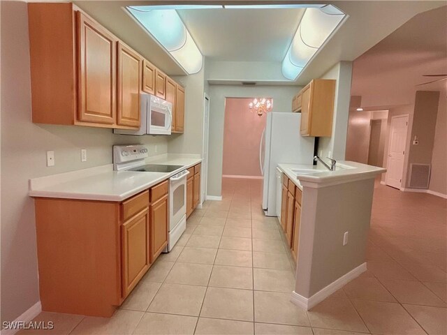 kitchen with sink, white appliances, and light tile patterned floors