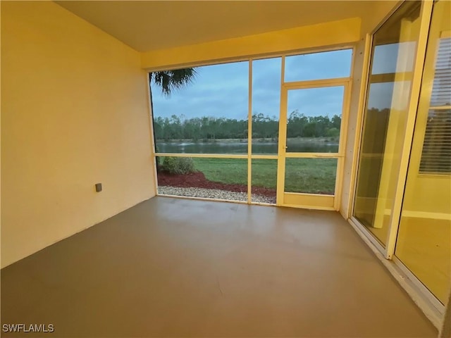 unfurnished sunroom featuring a water view