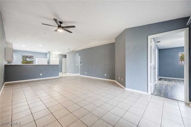 unfurnished room with ceiling fan, lofted ceiling, and light tile patterned flooring