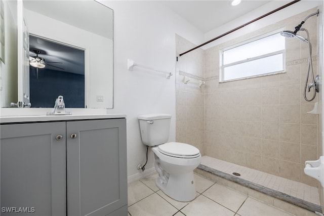 bathroom with a tile shower, toilet, tile patterned floors, and vanity